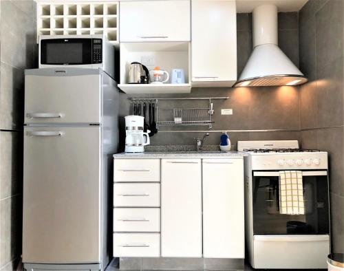 a white kitchen with a refrigerator and a microwave at Petite Maison in Buenos Aires