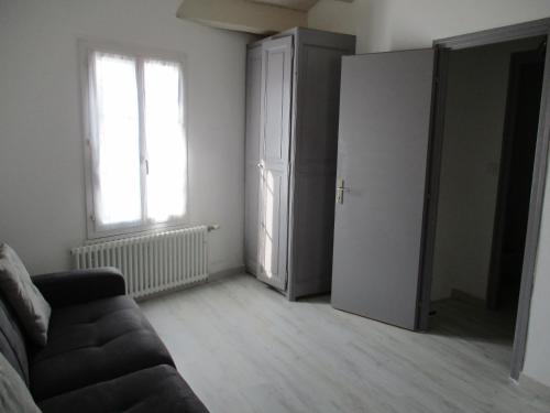 uma sala de estar com um sofá e uma janela em STUDIO 2 PERS PROCHE PLAGE ET COMMERCES em Sainte-Marie-de-Ré