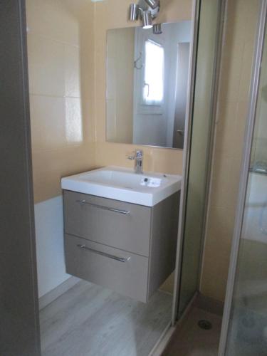 uma casa de banho com um lavatório branco e um espelho. em STUDIO 2 PERS PROCHE PLAGE ET COMMERCES em Sainte-Marie-de-Ré