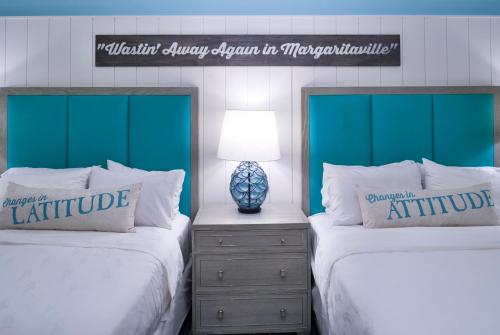 two beds in a bedroom with green headboards at Margaritaville Resort Gatlinburg in Gatlinburg