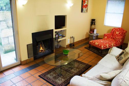 sala de estar con sofá y chimenea en Marwood Villas, en Halls Gap