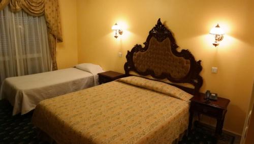 a hotel room with two beds and two lamps at Albergaria Malaposta in Pegões