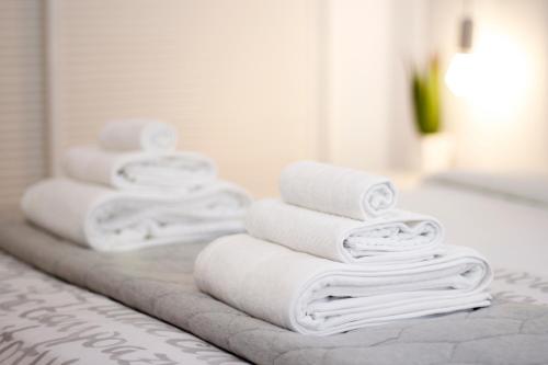 una pila de toallas blancas sentadas en el mostrador del baño en Apartment Design Marbella, en Estepona