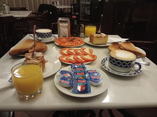 una mesa cubierta con platos de comida y zumo de naranja en Hotel Casa de Caldelas, en Castro Caldelas