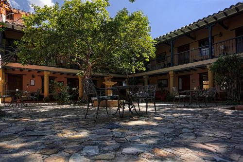 un patio avec des tables et des chaises en face d'un bâtiment dans l'établissement Hotel Plazuela de San Agustín, à Villa de Leyva