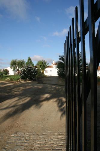 a fence in front of a road with a house at Monte Da Morena Agro-Turismo in Serpa