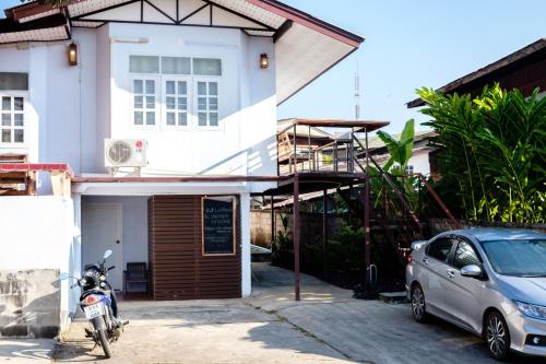 ein vor einem Haus geparkt in der Unterkunft P.L.P Guesthouse - Mae Hong Son in Mae Hong Son