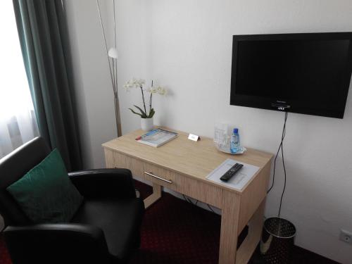 Una televisión o centro de entretenimiento en Hotel Sechzehn