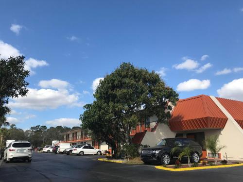 a car parked in a parking lot next to a building at Enterprise Motel in Kissimmee
