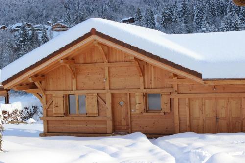 Cabaña de madera con nieve en el techo en Le Chalet d'Ulysse, en Arâches-la-Frasse