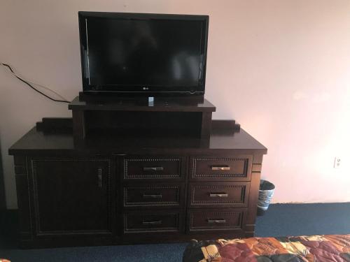 a tv on top of a dresser with a television on it at Enterprise Motel in Kissimmee