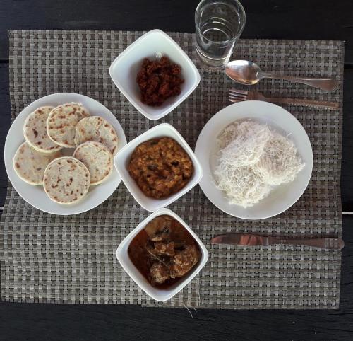 a table with plates of food and bowls of food at Majestic Beach Retreat in Kalpitiya