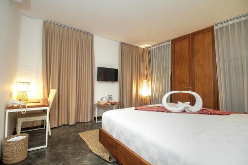 a hotel room with a large bed and a desk at Shankara Borobudur in Borobudur