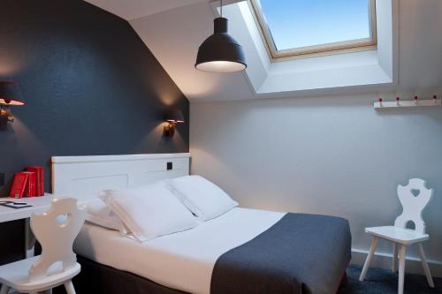 a bedroom with a bed and a desk and a window at Le Faucigny - Hotel de Charme & SPA in Chamonix-Mont-Blanc