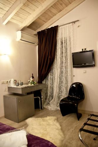 a room with a bed and a chair and a window at Grimani Pension in Nafplio