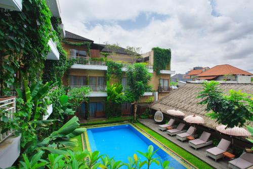 a hotel with a swimming pool next to a building at Hotel Puriartha Ubud in Ubud