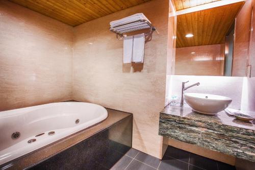 y baño con bañera y lavamanos. en Cai She Hotel, en Taipéi