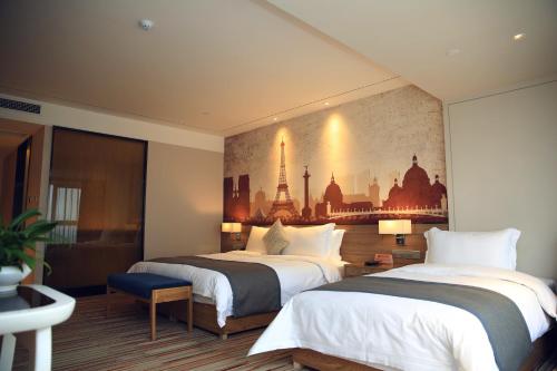 a hotel room with two beds and a painting on the wall at Chengdu Prolit Hotel in Chengdu