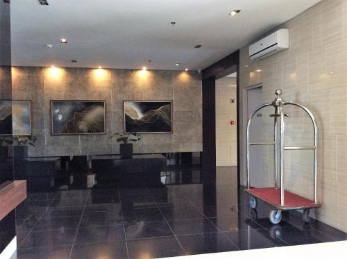 a bathroom with a shower and a bench and paintings at Wind Residence Condo - Tagaytay by jaderooms in Tagaytay