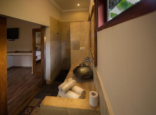 baño con lavabo y dispensador de papel higiénico en Nativo Lombok Hotel en Kuta Lombok