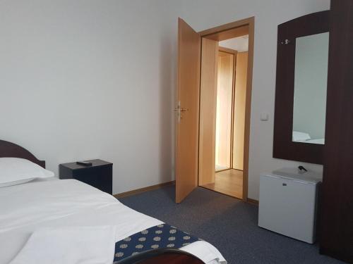 a bedroom with a bed and a mirror and a door at Pension Yasmine in Timişoara