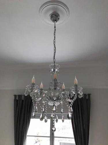 a chandelier hanging from a ceiling with a window at Dina's House in Spáta