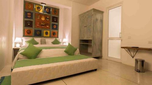 a bedroom with a large bed with green pillows at 18 Faces with free drop off to Galle Fort by TukTuk in Galle