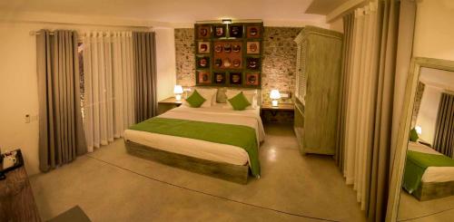 a bedroom with a large bed with green sheets at 18 Faces with free drop off to Galle Fort by TukTuk in Galle