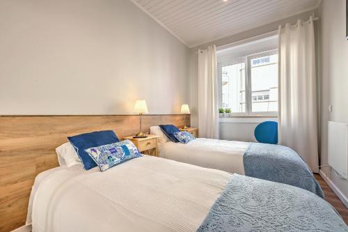 twee bedden in een kamer met een raam bij Lisboa Charming in Lissabon