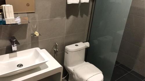 a bathroom with a white toilet and a sink at Diamond Inn in Kota Kinabalu