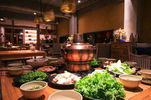 a table with plates of food and a pot on it at The Twelve Manor•Terraces Lodge in Yuanyang