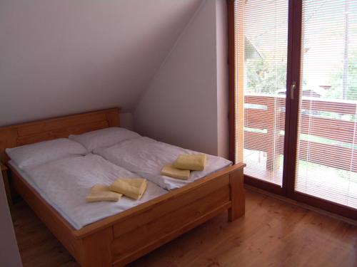 Penzión Admit في تيرشوفا: غرفة نوم عليها سرير ووسادتين صفراء