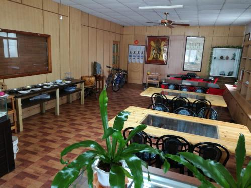 a salon with tables and chairs and a plant in a room at Tai Yu Ju Bao Fang B&B in Yongan