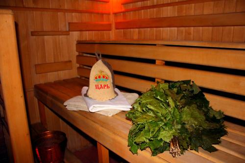 a wooden bench with a hat and a bunch of greens at "LiAn" Family Hotel & Restaurant in Volosyanka