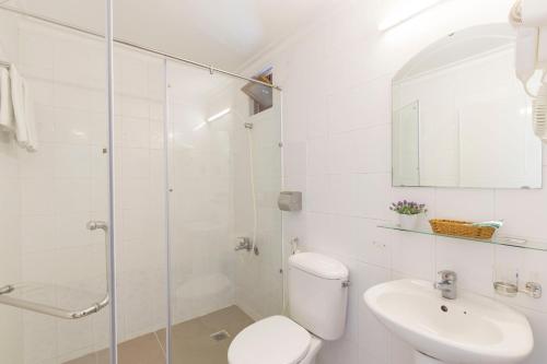 a white bathroom with a toilet and a sink at Spotlight Hotel in Ho Chi Minh City