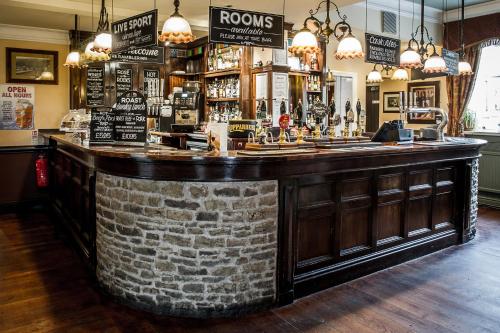 a bar in a pub with a brick wall at The Rambler Inn & Holiday Cottage in Edale