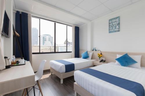 a hotel room with two beds and a window at Spotlight Hotel in Ho Chi Minh City