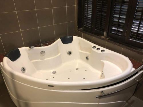 a large white bath tub in a bathroom at Gold Coast Morib in Morib