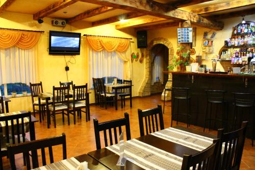 a restaurant with tables and chairs and a flat screen tv at "LiAn" Family Hotel & Restaurant in Volosyanka