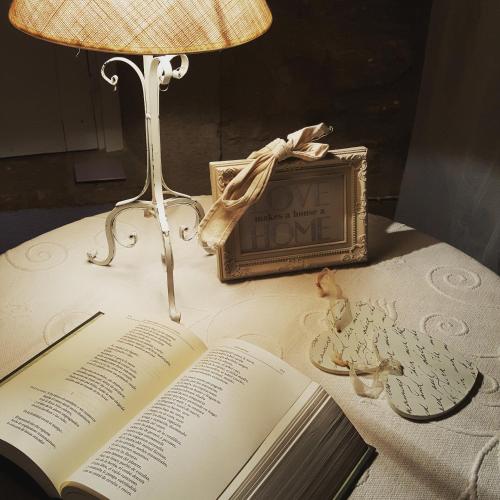 an open book on a table with a lamp and a clock at Carmen De Arnas in Colungo