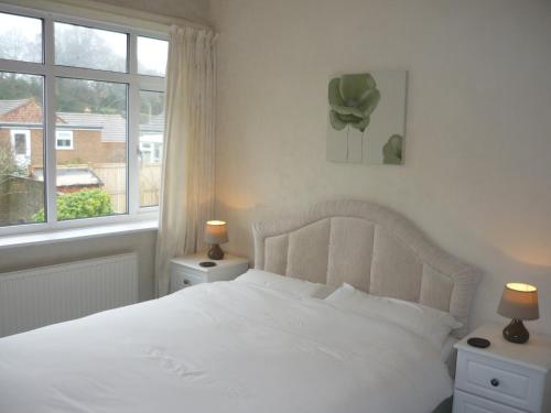 a bedroom with a white bed and a window at De La Warr Guest House in Bexhill