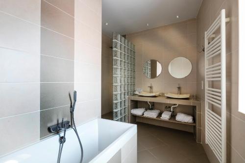 La salle de bains est pourvue d'une baignoire et d'un lavabo. dans l'établissement Chambres d'Hôtes La Maison de Léonie, à Collias