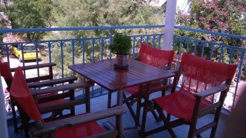 Smaragdi Studios and Rooms في أغيوس كيريكوس: طاولة خشبية مع كراسي ونبات الفخار على الشرفة