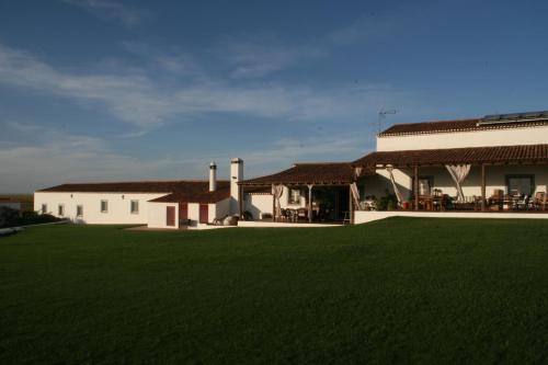 a house with a green lawn in front of it at Monte Da Morena Agro-Turismo in Serpa