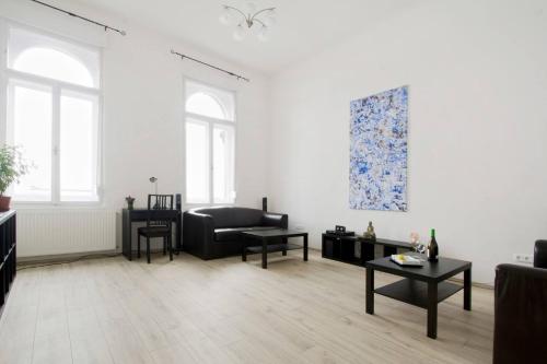 een woonkamer met een bank en een tafel bij Apartment Andrassy in Boedapest