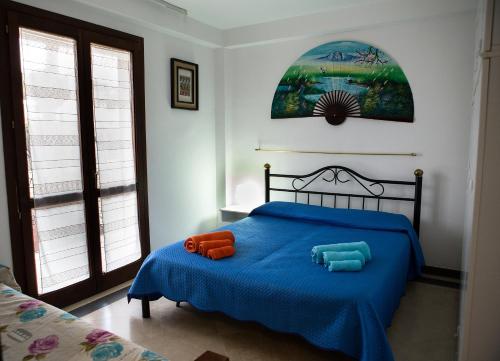 マリーナ・ディ・ラグーザにあるVilletta a Marina di Ragusaのベッドルーム1室(青いベッド1台、枕2つ付)