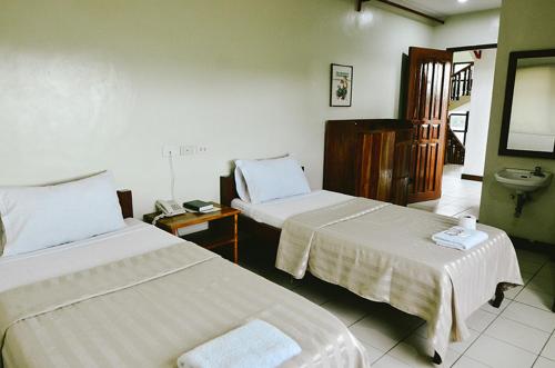 Habitación de hotel con 2 camas y lavamanos en El Haciendero Private Hotel, en Iloilo City