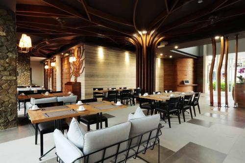 comedor con mesas y sillas de madera en Mahogany Hotel, en Nusa Dua
