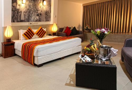 a hotel room with a bed and a couch at Thilanka Hotel in Kandy