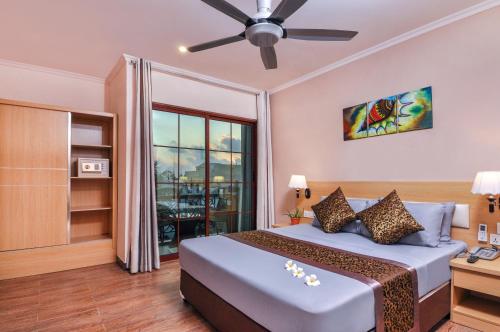 a bedroom with a large bed and a large window at Triton Beach Hotel & Spa in Maafushi